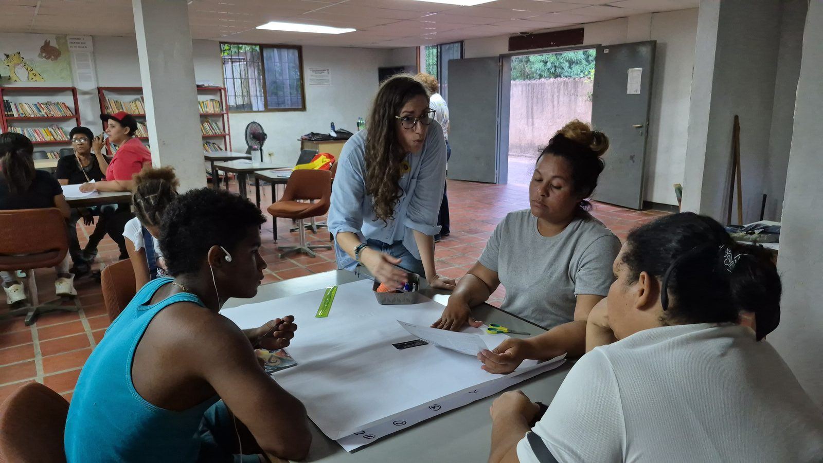 Participantes trabajando alrededor de una mesa sobre un papelógrafo