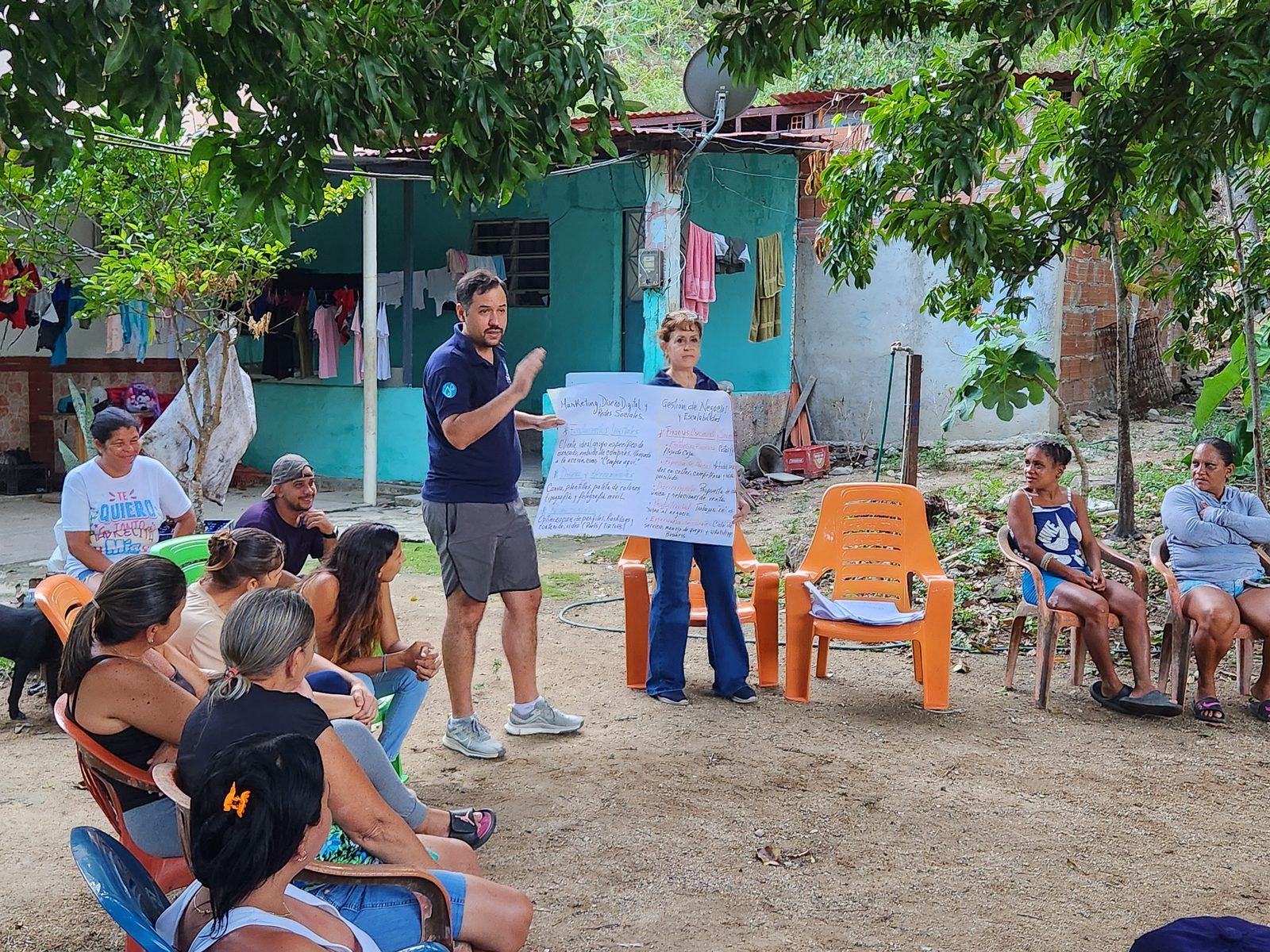 Taller al aire libre: un facilitador presenta un rotafolio a un grupo de la comunidad