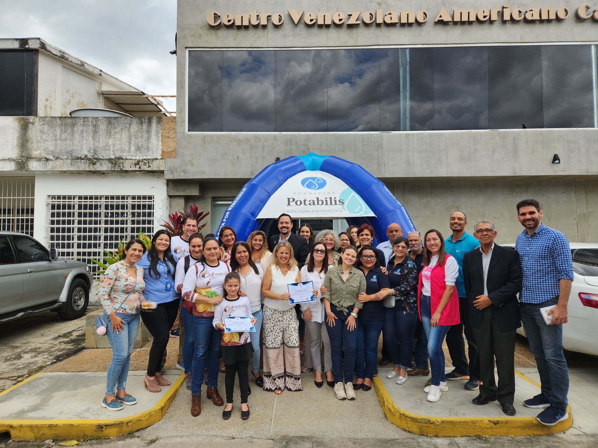 Equipo de Fundación Potabilis y participantes de una formación, reunidos frente a una sede con el arco de Potabilis